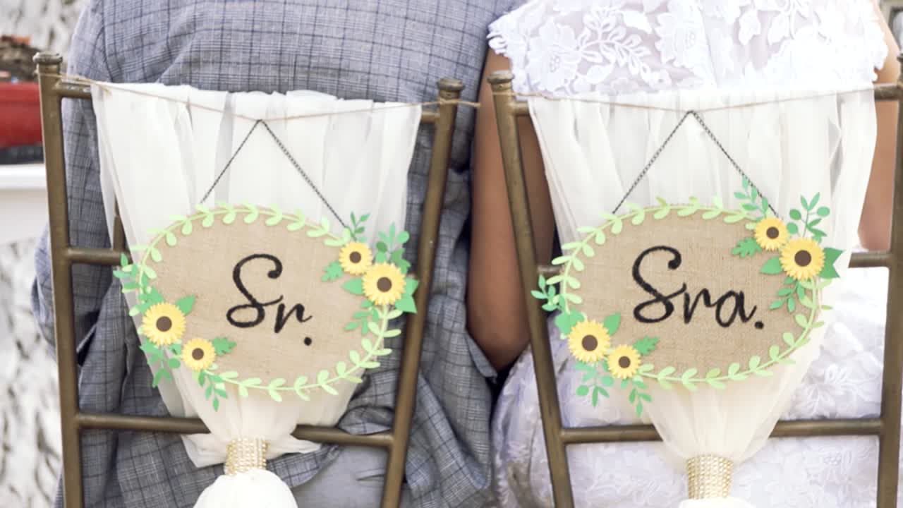 Vista posteriore di una coppia seduta durante la loro cerimonia di matrimonio all'aperto