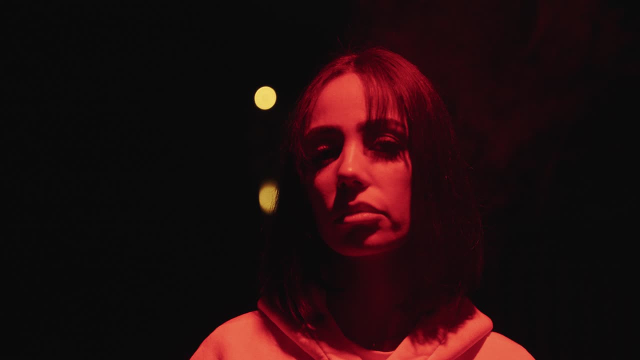 young woman with short hair smoking in red light with slow motion