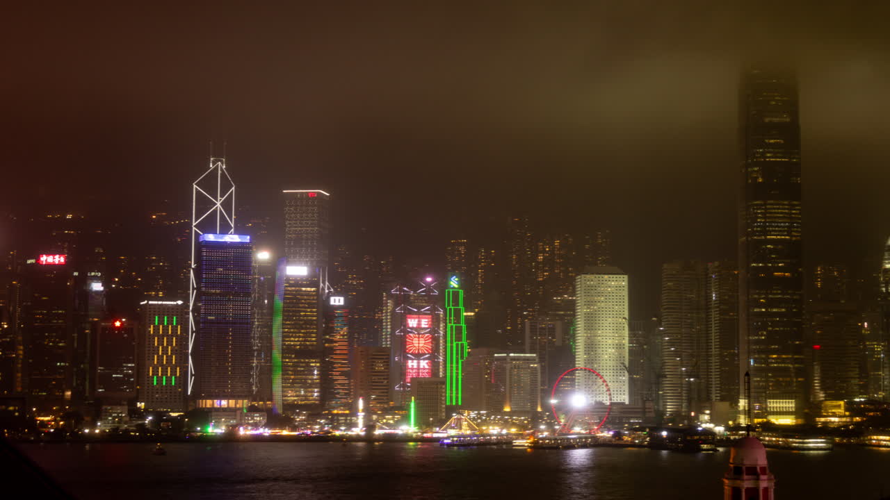 HONG KONG - 19 MARCH 2025 : Hong Kong Central city skyline filmed from across the harbour in kowloon with all the skyscrapers lit up at night advertisements