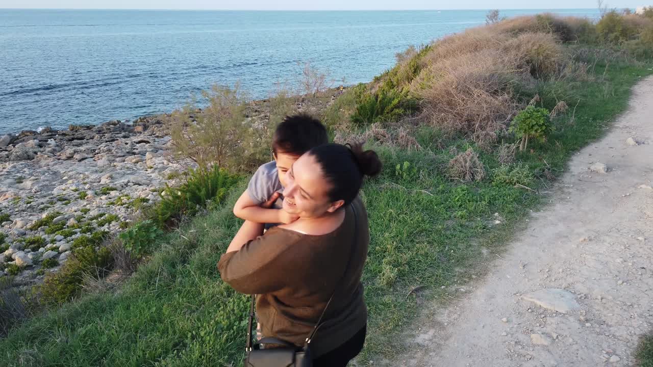 어린 어머니는 어린아이를 회전시키고 카메라를 향해 혀를 어 니다.