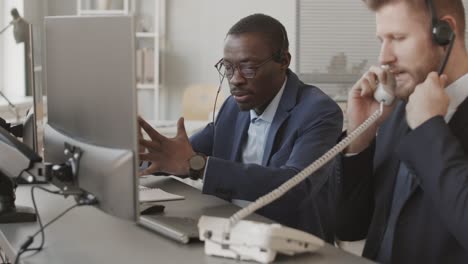 male brokers in headsets talking to clients