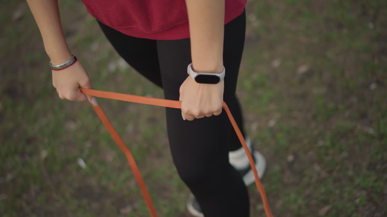 Fitness Band Visible, Lifestyle Activity With Wrist Device And Resistance Band Exercise, Engaging In Outdoor Fitness Routines Wearing Smartwatch While Exercising With Resistance Band On Wrist