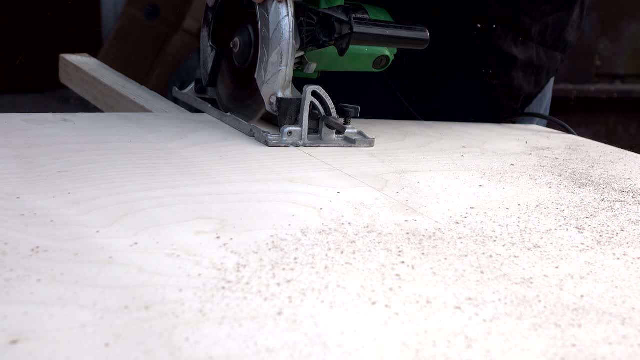 резать дерево с помощью электрической ручной пилы. деревообработка.