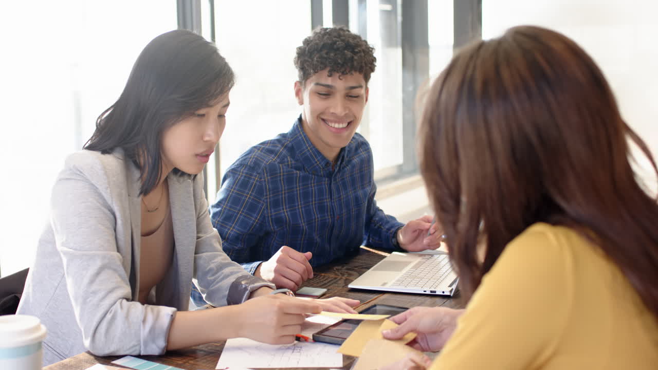 Interior design project, multiracial team collaborating with documents and laptop in office