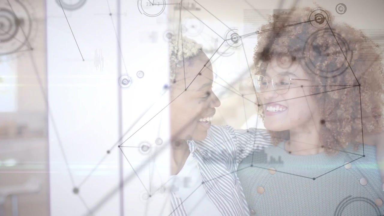 Due donne adulte che alzano la mano, indicando un HUD di dati con nodi e grafici, abbracciandosi e condividendo intuizioni.