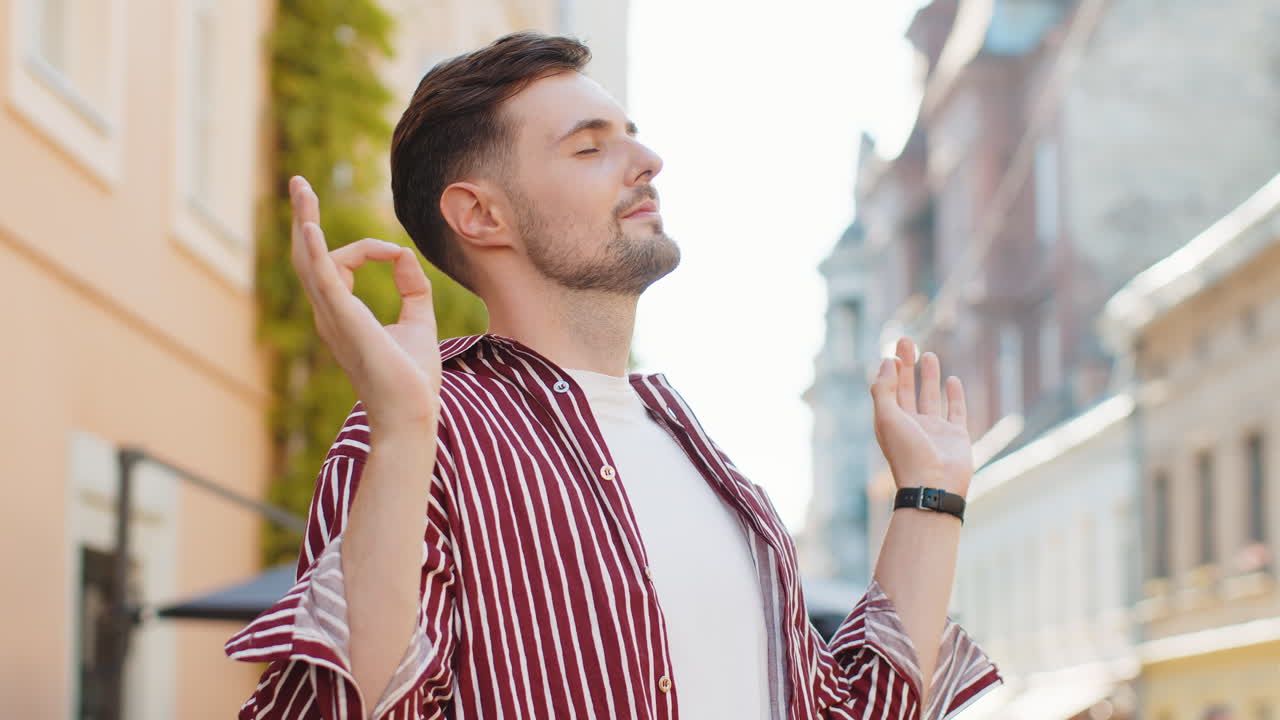수염이 있는 성인 남자가 휴식을 취하고, 눈을 감고 명상하고, 도시 거리에서 야외에서 평화로운 마음으로