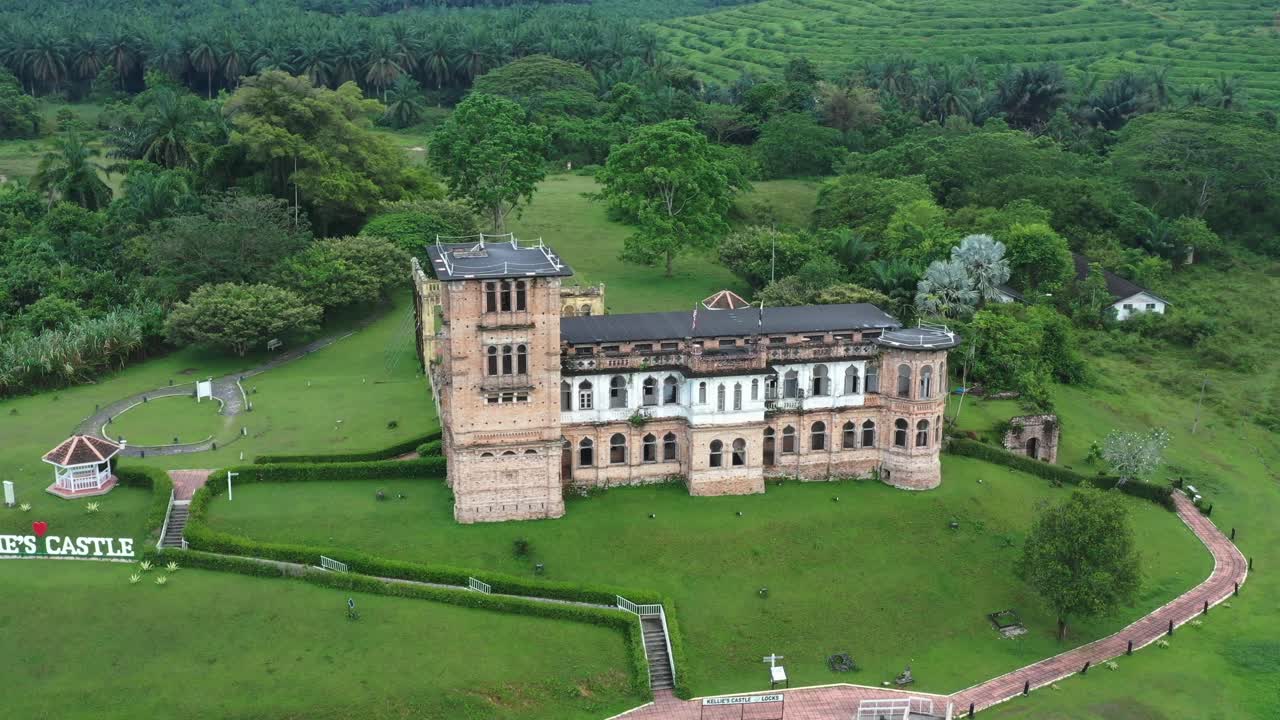 Cinematic drone fly around historic landmark Kellie's castle next to Raya river, tilt down birds eye view reveals the details of unfinished ward at Batu Gajah, Kinta District, Perak, Malaysia.