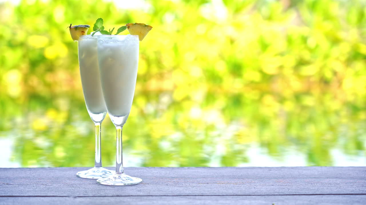 Close up view of fresh smoothy fruit juice on a glass with a straw and a slice of fruit on the wooden table