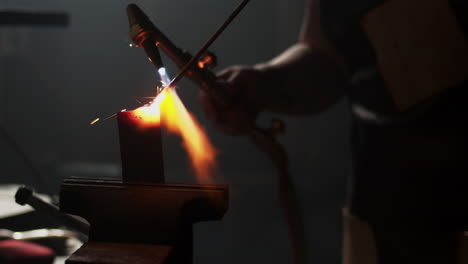 red hot sparks fly as blacksmith welds two pieces of metal together