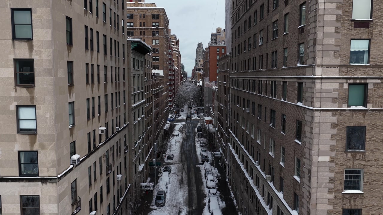 A cinematic descending drone shot of buildings in downtown Manhattan covered in a fresh layer of snow.