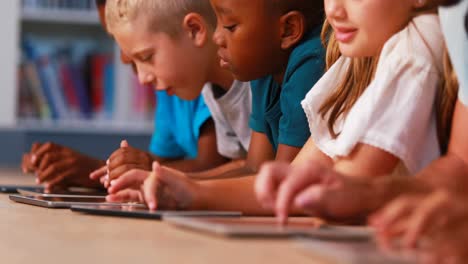 Niños-De-Escuela-Usando-Tableta-Digital-En-La-Biblioteca