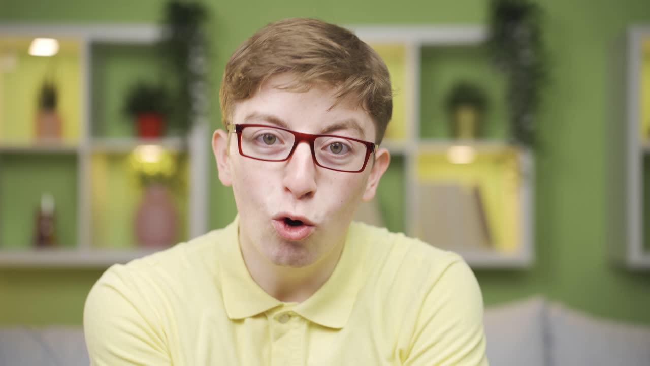 재미있는 얘기하는 젊은 남자가 카메라 클로즈업으로 보고 있습니다.