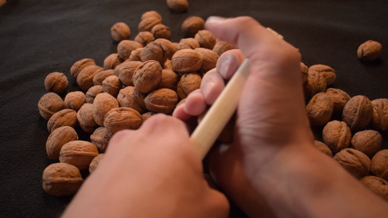 Young man is cracking some fresh dried walnuts-8