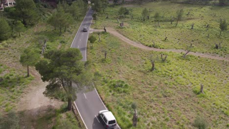 Das-Auto-Fährt-Tagsüber-Auf-Einer-Kleinen-Straße-Auf-Der-Insel-Mallorca-In-Spanien,-Aus-Der-Luft