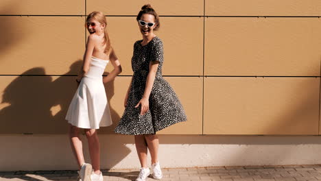 two happy women in stylish dresses