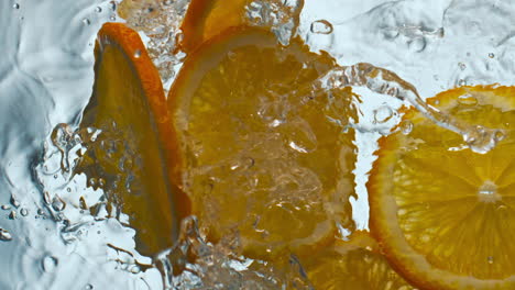 pieces orange dropped water in super slow motion closeup. citrus fruit splashing