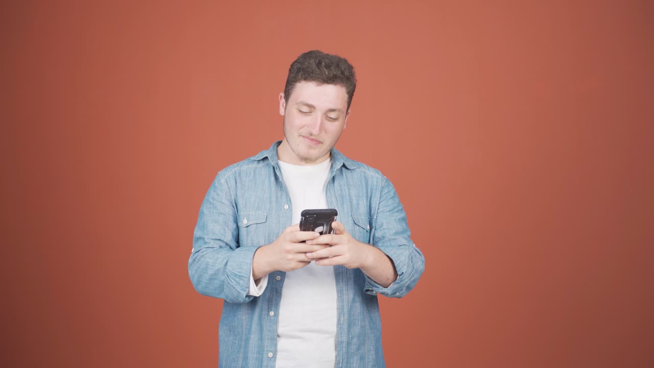 행복한 남자가 전화로 문자 메시지를 보내고 웃고