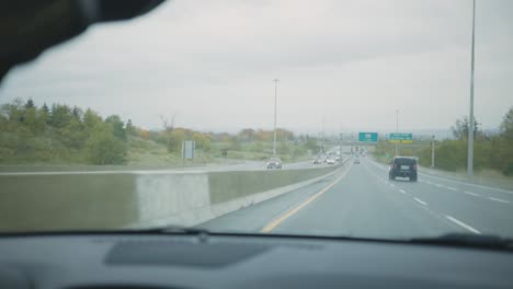 Wipers-Clearing-Windshield-Of-A-Car-Driving-On-The-Highway---handheld,-slow-motion