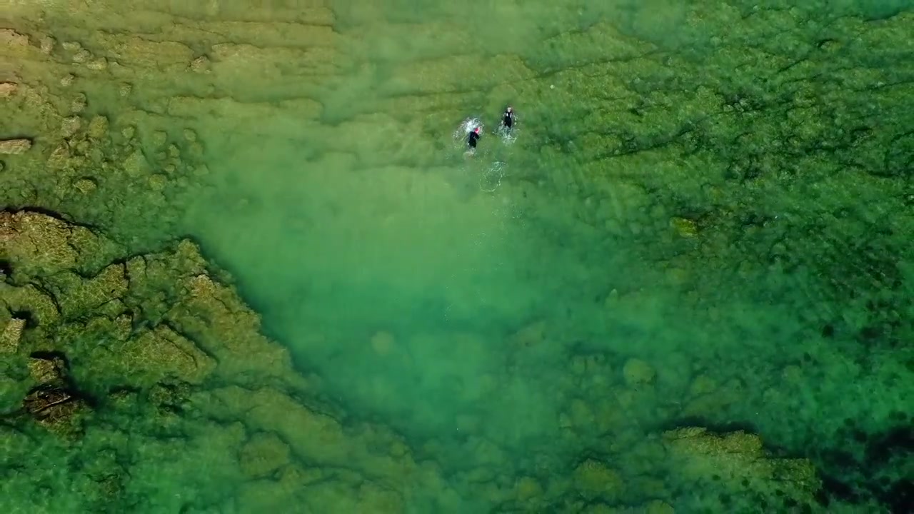 Vista aerea con drone di persone che nuotano nell'oceano a French Beach, Karachi, Pakistan.
