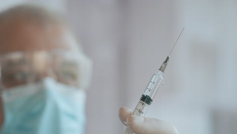 Doctor-Preparing-Syringe.-doctor-preparing-syringe-for-injection.-Female-doctor-or-nurse-holding-syringe-with-liquid-close-up.-Medicine-and-vaccination.-High-quality-4k-footage