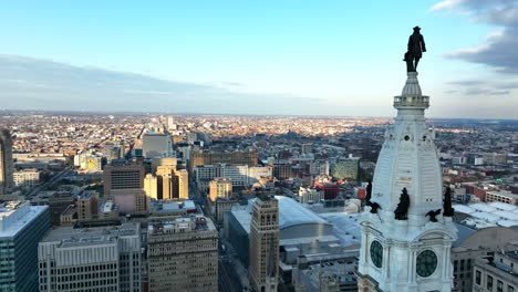 cinematic shot of city hall clock tower and william penn statue overlooking philly skyline