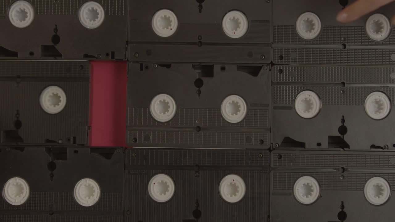 VHS cassettes on burgundy background