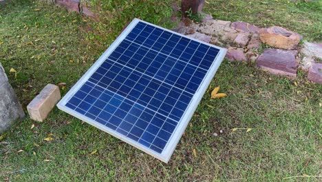 closeup of a small solar pannel installed on the garden, small portable solar panel on the lawn for clean energy
