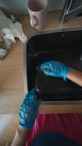 cleaning a baking dish in the kitchen sink