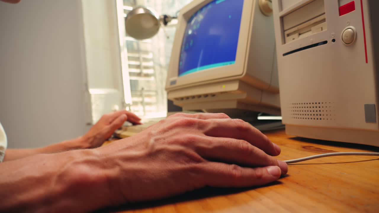 Man working and gaming on retro computer PC, IT engineer with vintage computer at home, using old fashion technology, close up of retro setup.