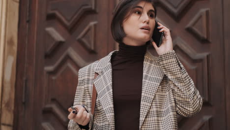 caucasian businesswoman using smartphone outdoor.