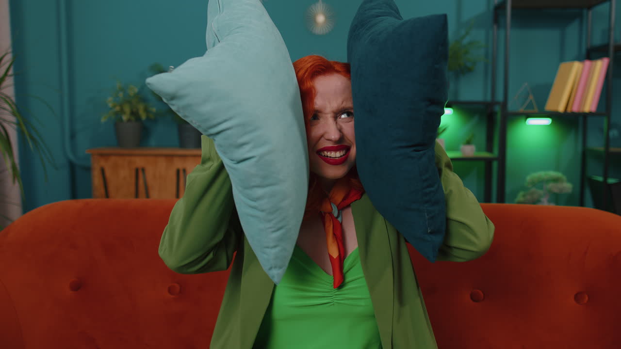 이웃의 수리 작업 개념, 집에서 짜증나는 소녀는 소음으로 짜증나는 베개로 귀를  ⁇ 습니다.