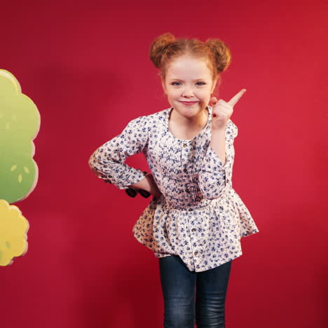 little cute little girl in the studio. cute redheaded child on red background square video