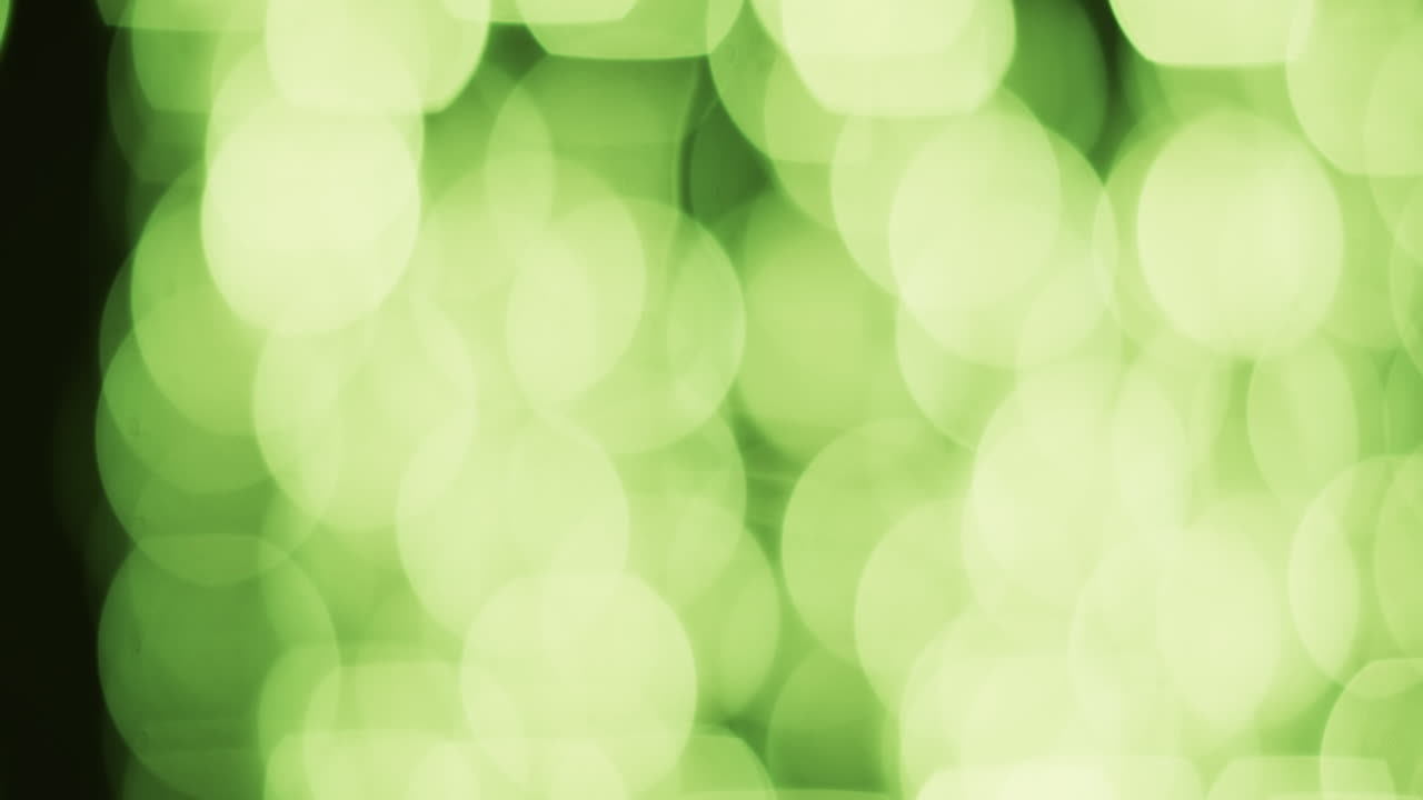 Video von flackernden weißen und grünen Bokeh-Lichtflecken mit Textfreiraum