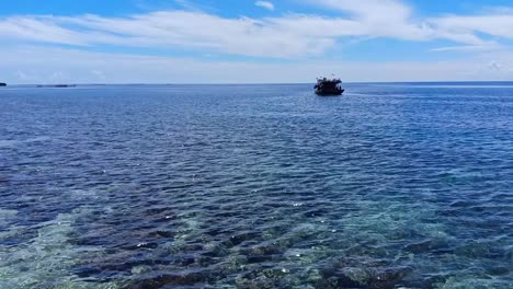 The-boat-cruises-in-the-sea-waters-on-Karampuang-Island,-West-Sulawesi,-Indonesia