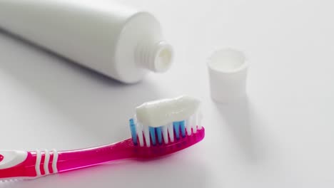 Video-of-close-up-of-toothbrush-and-paste-on-white-background