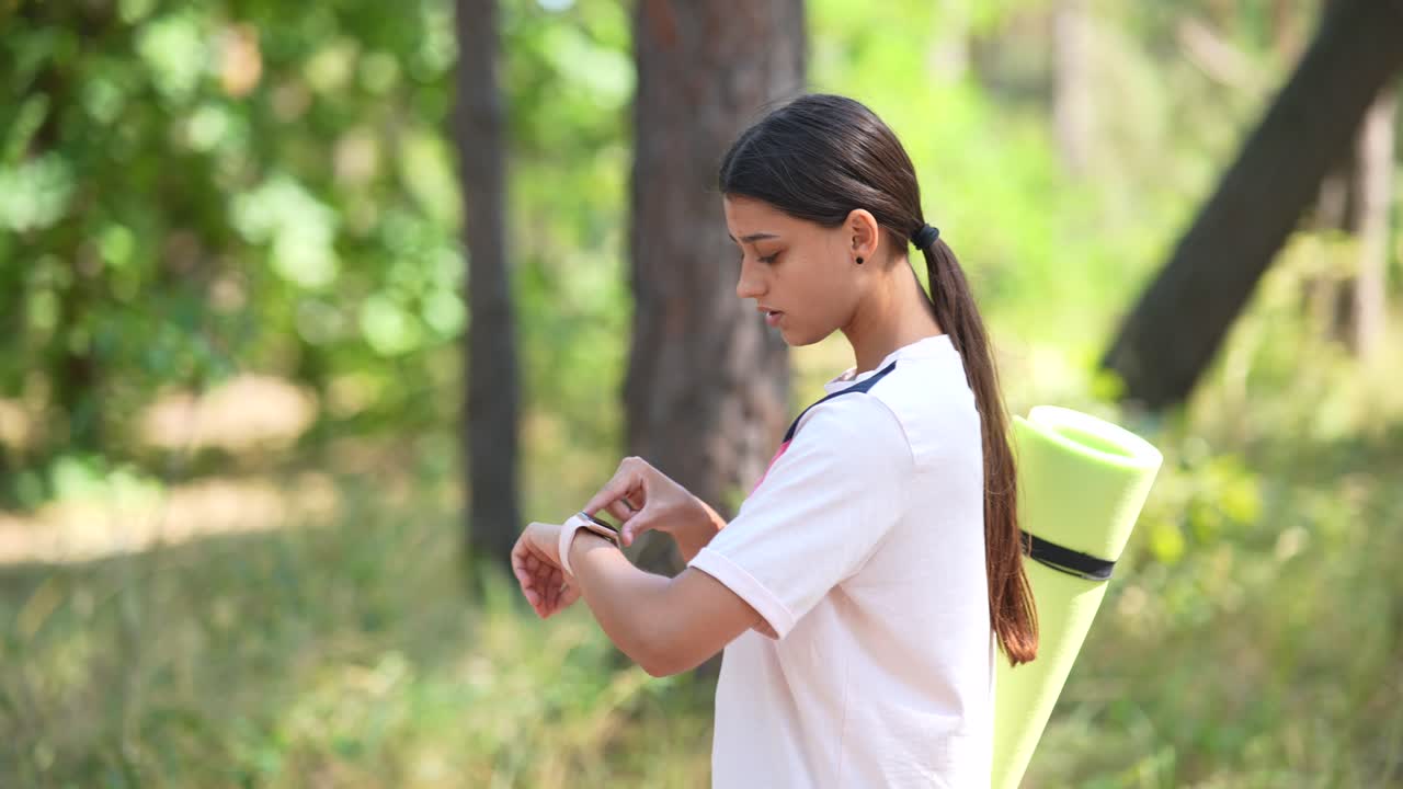 Teenage girl checking her smartwatch outdoors