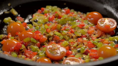 onion, paprika and cherry tomato cooking in a pan with butter