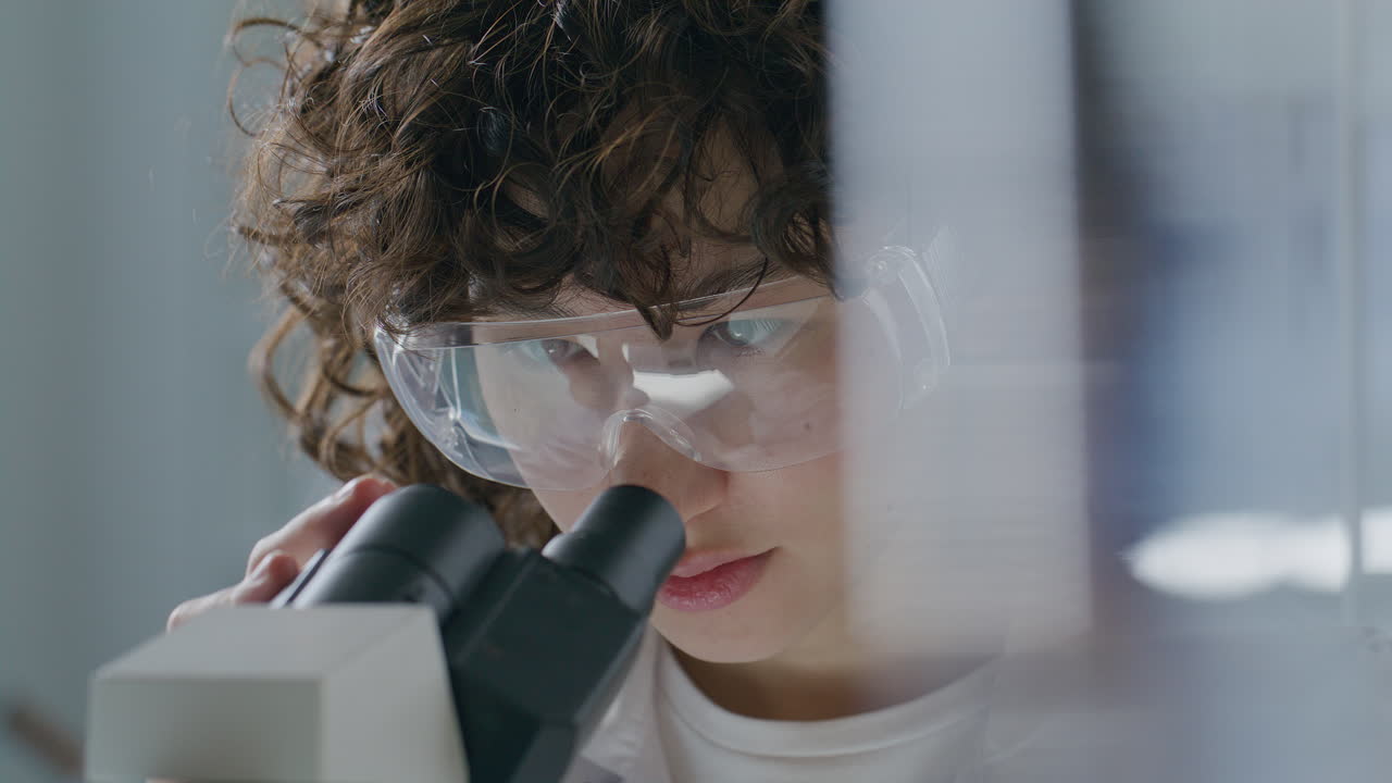 Close-Up of Female Scientist Analyzing Specimen under Microscope