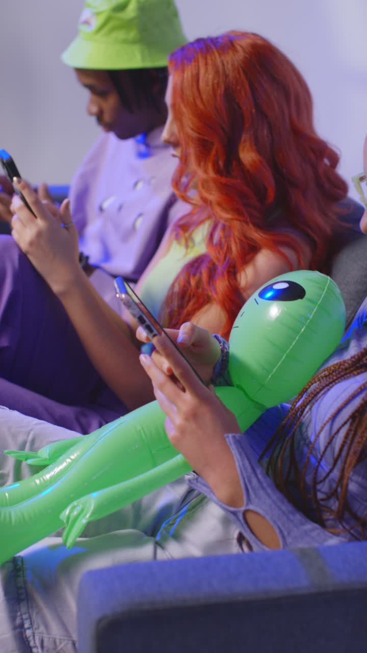 video de estudio vertical de un grupo de jóvenes amigos de la generación z jugando a la transmisión y usando las redes sociales en teléfonos móviles