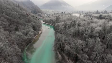 hermoso río turquesa fluye pacíficamente en la mañana de invierno brumoso, aéreo