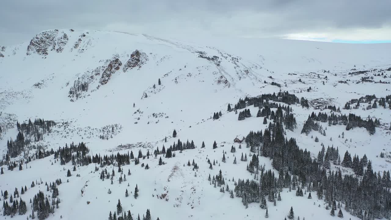 Puncak Gunung Bersalju dengan Hutan Konifer dan Kabin Pedesaan di Winter Park, Colorado
