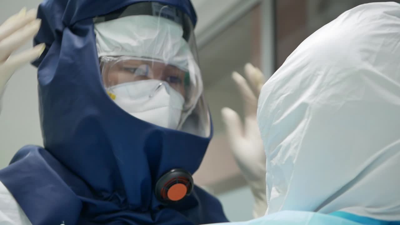 personal médico poniéndose trajes de papr antes de ingresar a la sala covd-19