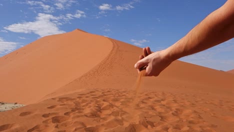 sand falls from a hand's man on a dune in namib-naukluft national park sossusvlei. namibia. africa.