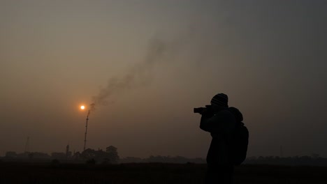 silhouette of photographer with camera taking pictures on environment pollution