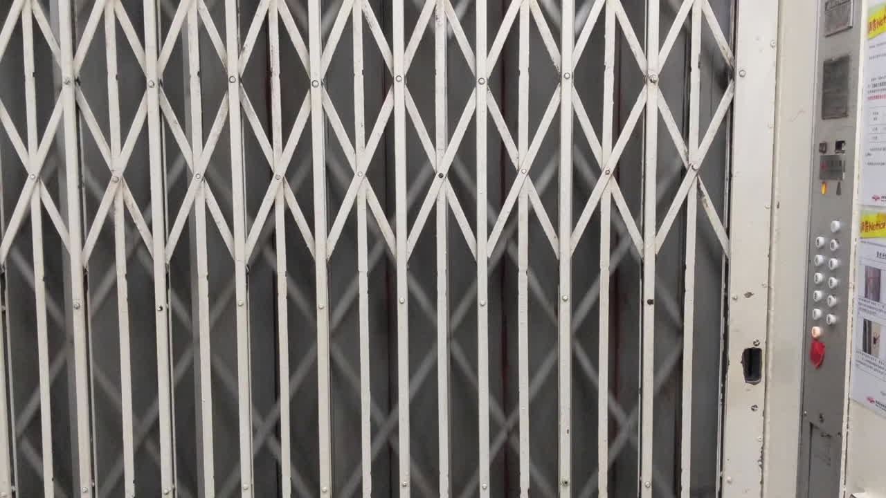 puerta de tijera manual del ascensor de estilo antiguo que desciende en un edificio en hong kong