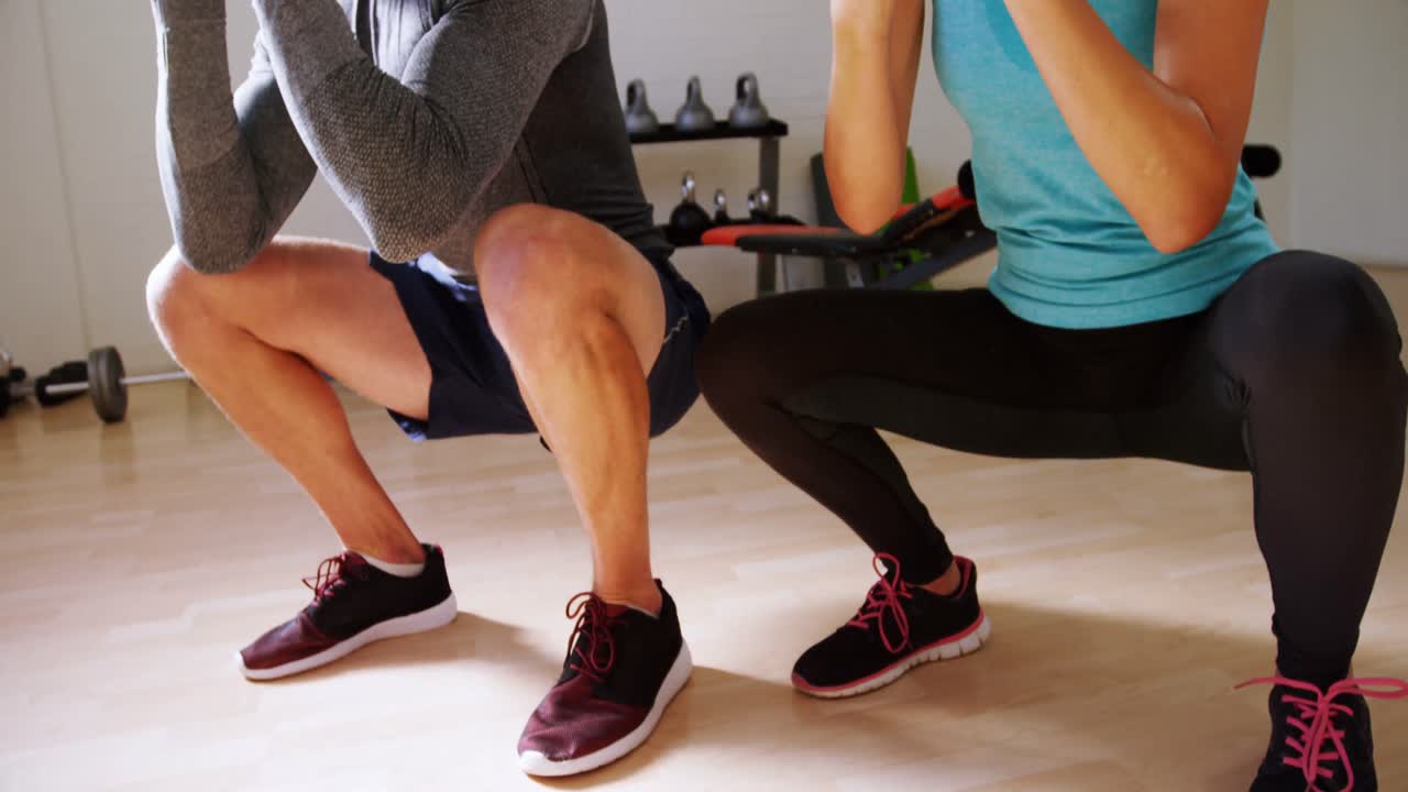 hombre y mujer haciendo ejercicio con kettlebell 4k