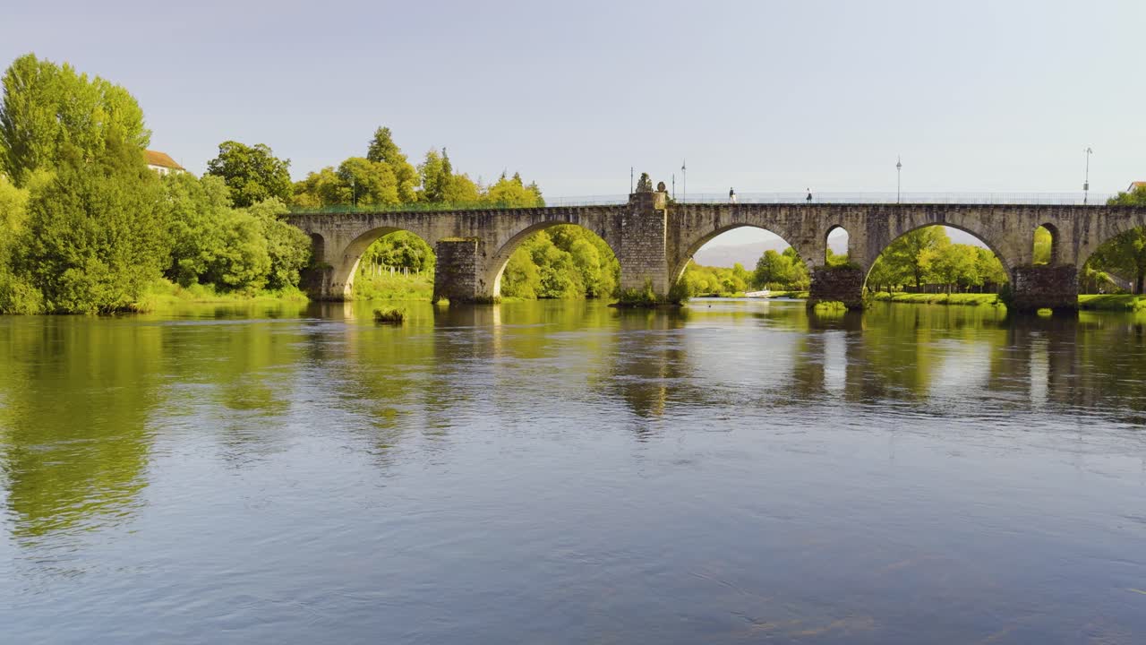 The flats of the Lima river flowing under the old roman bridge in Ponte da Barca