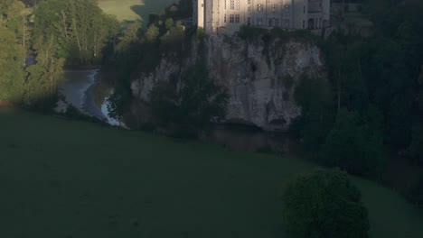 Tilt-up-shot-of-Walzin-Castle-on-cliff-during-sunrise,-aerial