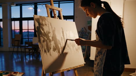 woman painting in an art studio at sunset
