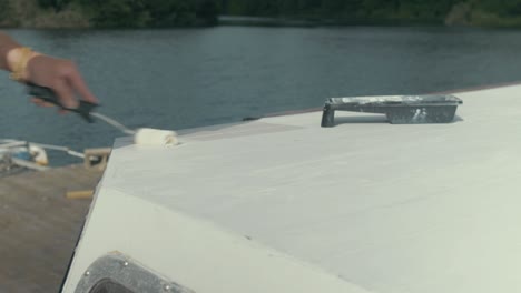 Painting-roof-planks-using-roller-on-wood-boat